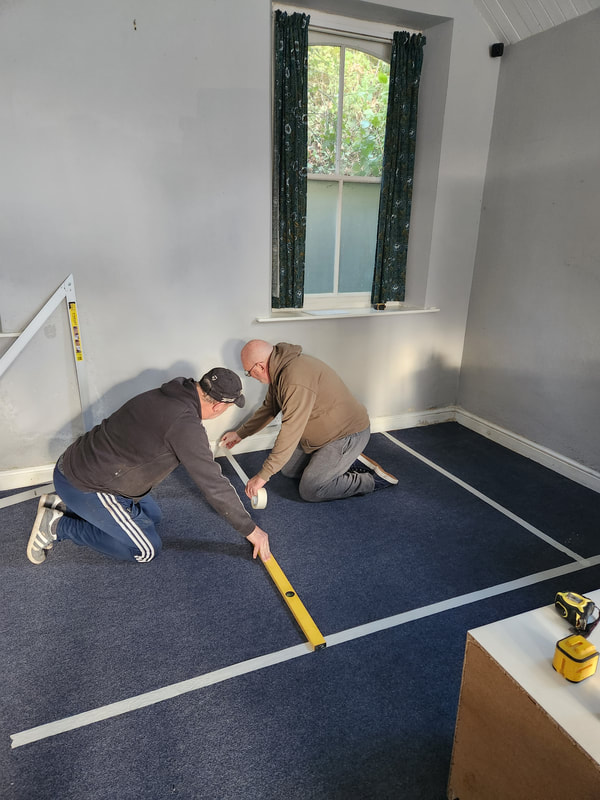 Men measuring the floor space